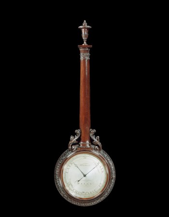 Wheel barometer, ca. 1770–80, 43 × 14 × 2.25 inches. Dial, silvered, signed ‘Whitehurst Derby’ with 3-inch scale for 29-31 inches of mercury subdivided into hundredths and inscribed for changeable, rain, fair. Case: mahogany, carved with leaves, column (housing the tube) with acanthus leaves at base, and urn finial. Made by Whitehurst of Derby.